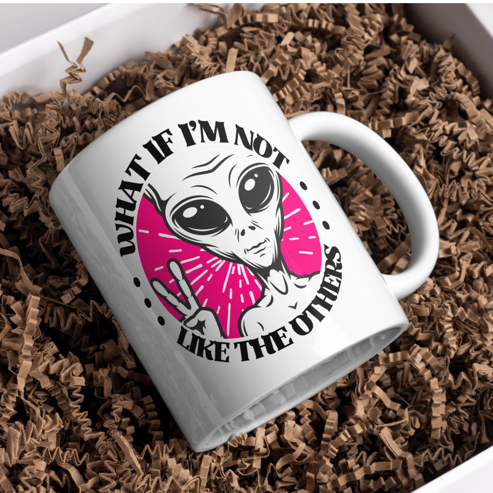 White mug with alien design and text on brown crinkle paper